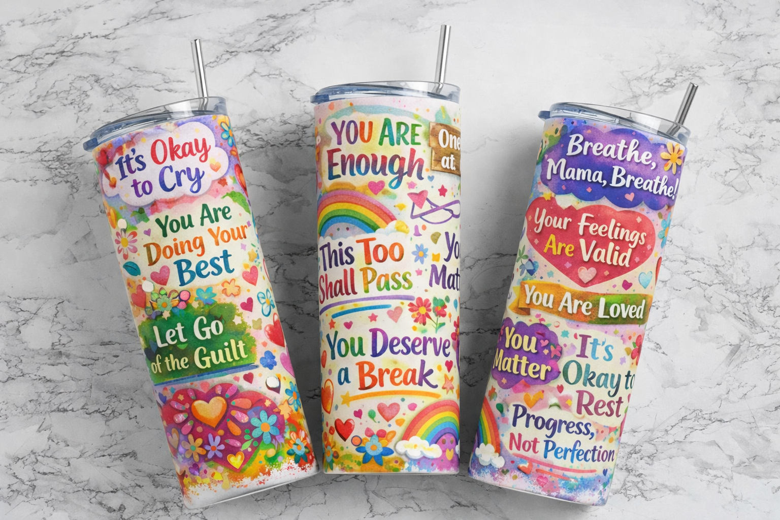 Three colorful tumblers with motivational phrases on a marble background